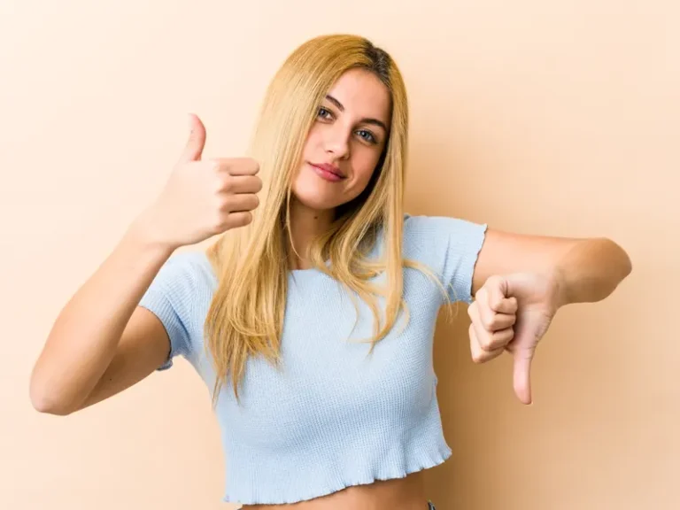 Fiatal nő a szőrtelenítési módszerek előnyeit és hátrányait jelképezve mutat fel egy like és egy dislike jelet